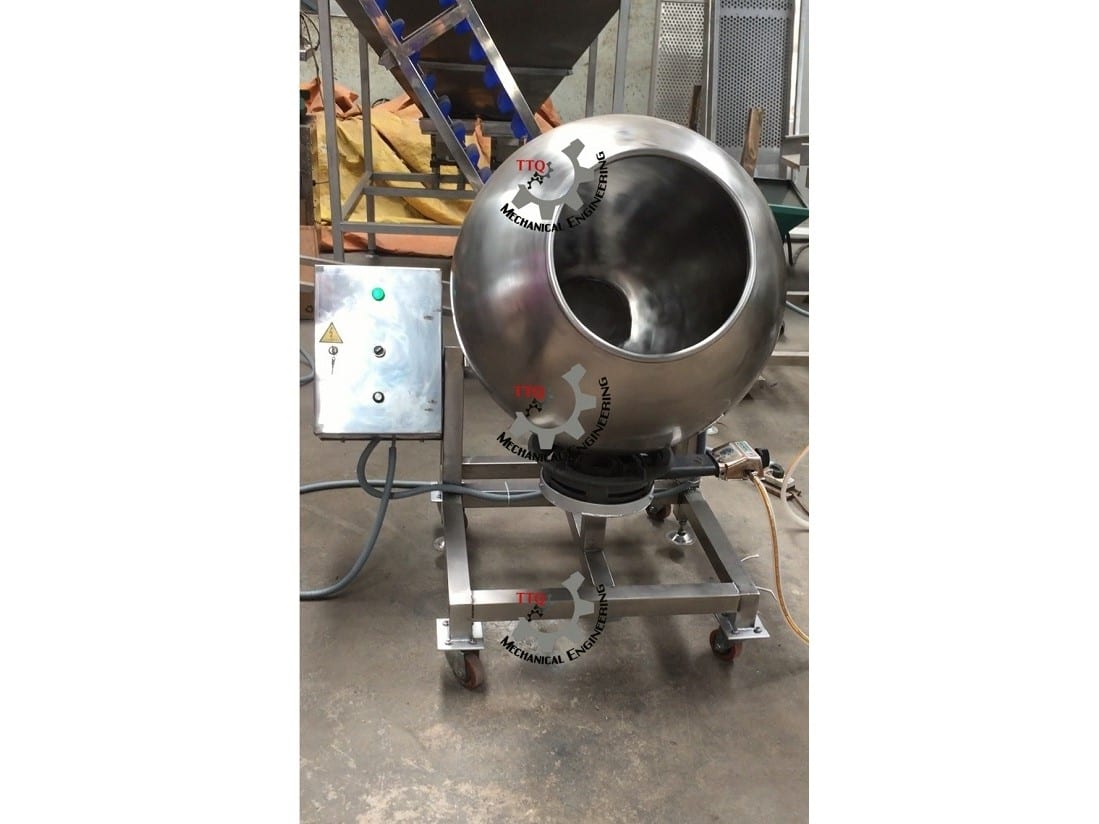 A TTQ sugar-coating pan tilted on its frame, with its control box