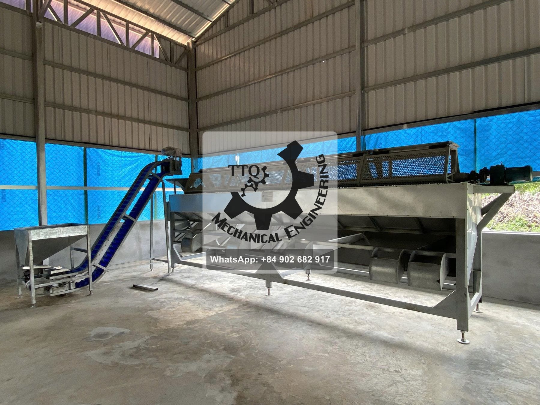A raw cashew nut grading machine installed, with graded discharge chutes