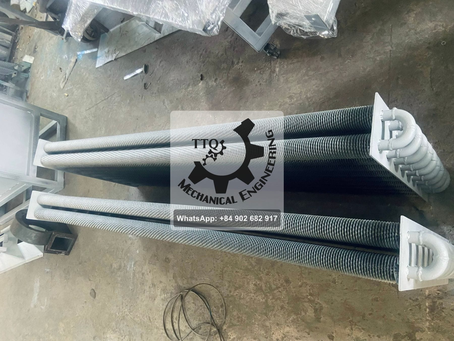 Finned steam heating coils with return-bend headers, before installation in a dryer
